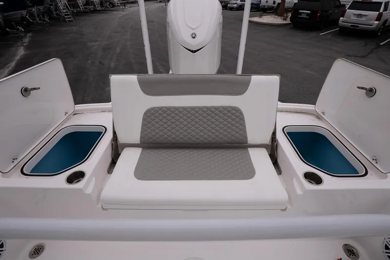 Slide: The Image of 2025 Caymas 26 HB boat seating area with storage compartments and cup holders. - 15