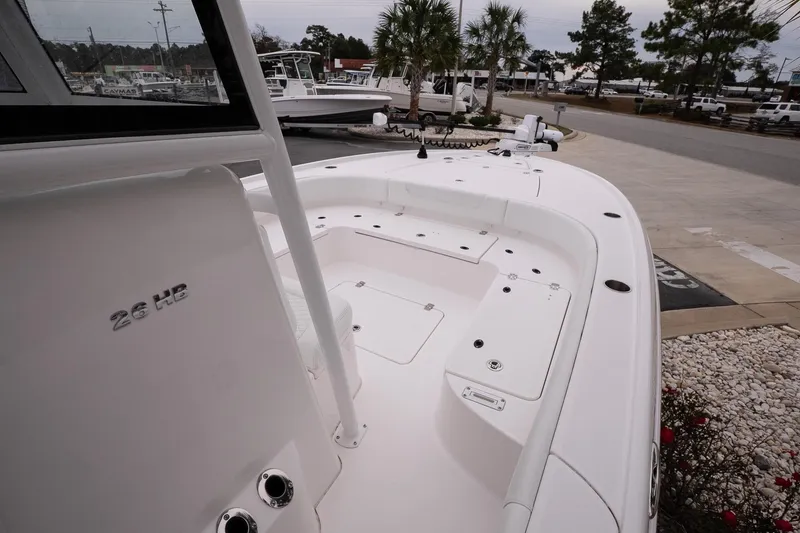 Slide: The Image of 2025 Caymas 26 HB boat, white deck, spacious layout, parked outdoors. - 17
