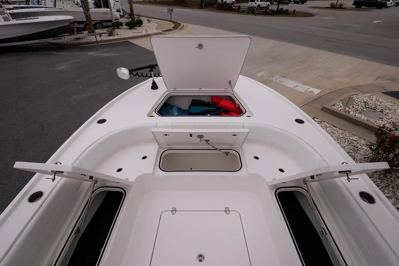 Slide: The Image of 2025 Caymas 26 HB boat deck with open storage compartments and safety gear. - 18