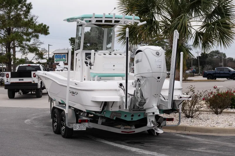 Slide: The Image of 2025 Caymas 26 HB boat on trailer with Yamaha 350 engine, parked near palm trees. - 5