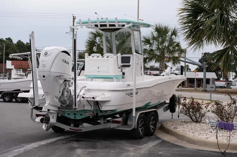 Slide: The Image of 2025 Caymas 26 HB boat on trailer with Yamaha 350 engine, parked near palm trees. - 7