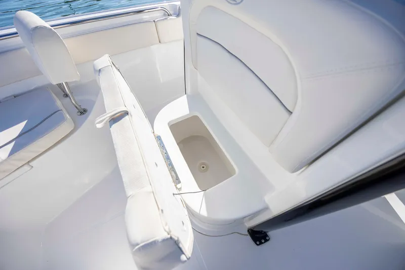Slide: The Image of 2024 Sea Hunt Ultra 239 SE boat interior with white seating and storage compartment. - 13