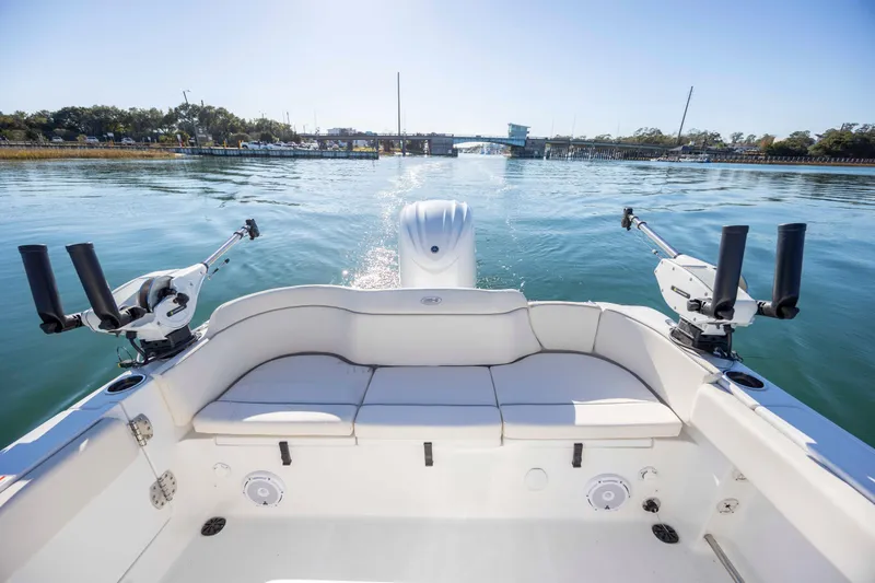 Slide: The Image of 2024 Sea Hunt Ultra 239 SE boat interior with fishing rod holders on calm water. - 21