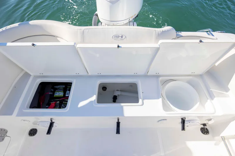 Slide: The Image of 2024 Sea Hunt Ultra 239 SE boat storage compartments with battery and utility access. - 22