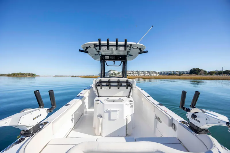 Slide: The Image of 2024 Sea Hunt Ultra 239 SE boat on calm water, clear blue sky. - 25