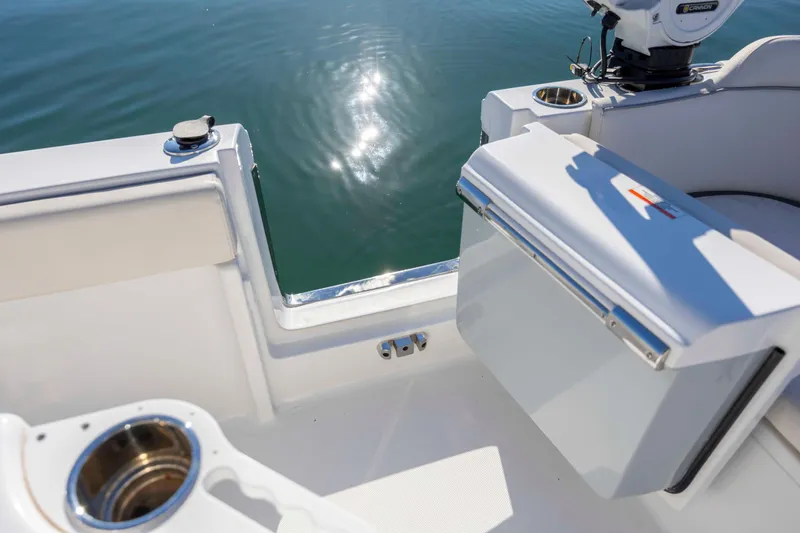 Slide: The Image of 2024 Sea Hunt Ultra 239 SE boat interior with cup holders and water reflection. - 28