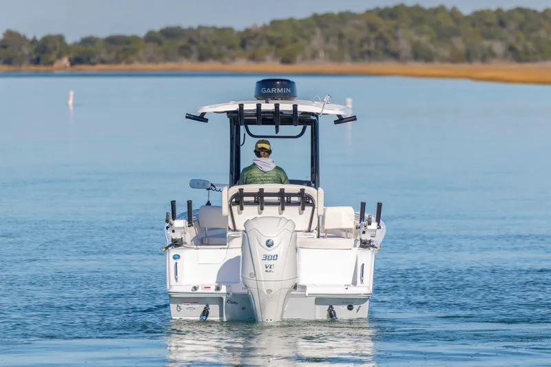Slide: The Image of 2024 Sea Hunt Ultra 239 SE boat cruising on calm water, rear view. - 3