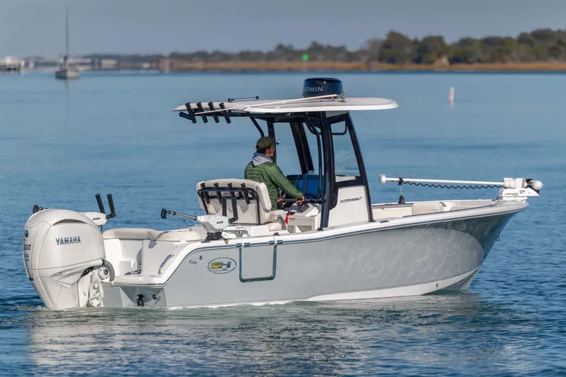Slide: The Image of 2024 Sea Hunt Ultra 239 SE boat cruising on calm water with Yamaha engine. - 4