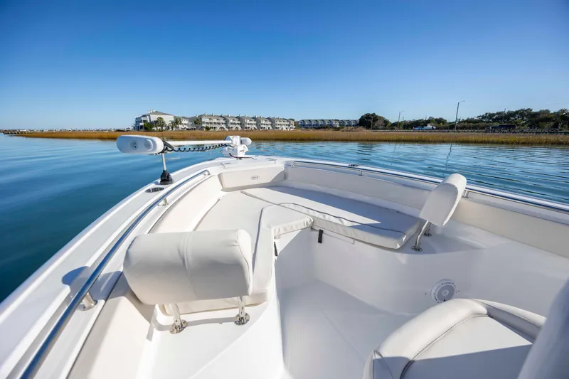 Slide: The Image of 2024 Sea Hunt Ultra 239 SE boat on calm water, showcasing luxurious seating and sleek design. - 8