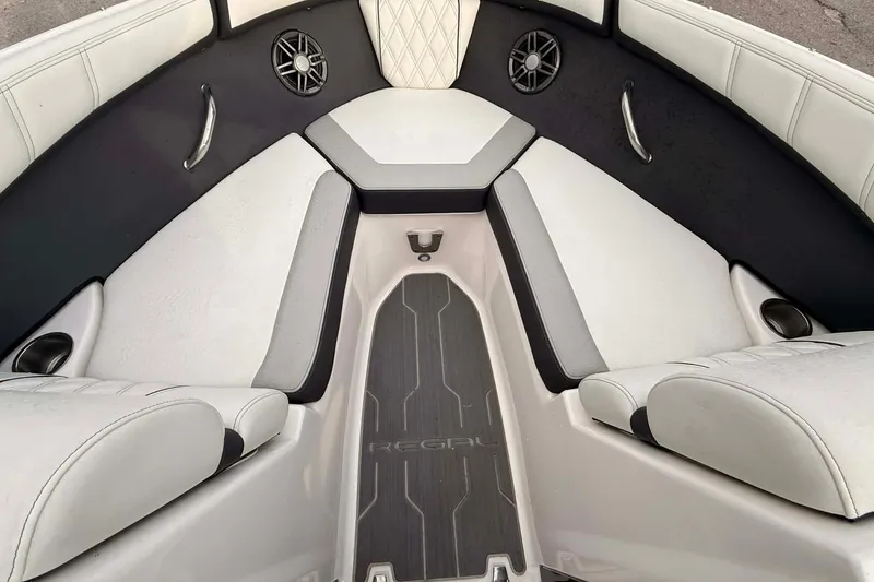 Slide: The Image of 2023 Regal 21 OBX boat interior with cushioned seating and speakers. - 6