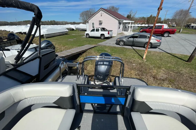 Slide: The Image of 2026 Starcraft VX 20 R DH pontoon boat with outboard motor in a yard setting. - 4