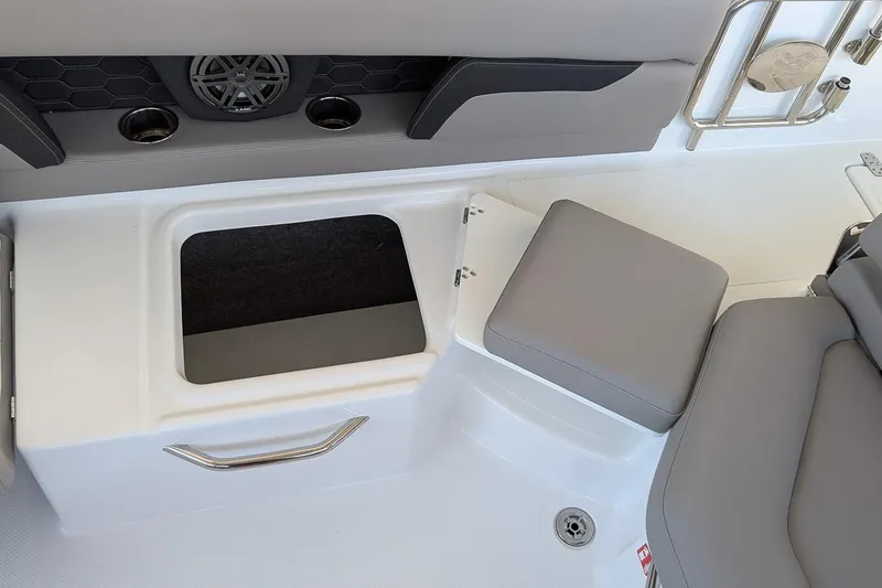 Slide: The Image of 2026 Four Winns HD5 OB boat interior with open storage compartment and cushioned seating. - 11