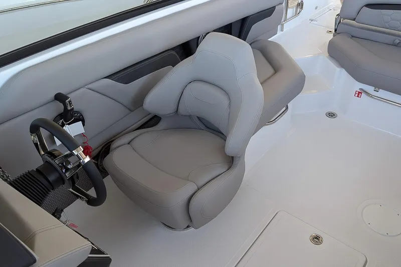 Slide: The Image of 2026 Four Winns HD5 OB boat interior with sleek gray seating and modern steering wheel. - 12