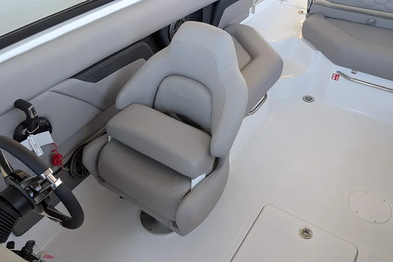 Slide: The Image of 2026 Four Winns HD5 OB boat interior with gray captain's chair and steering wheel. - 13