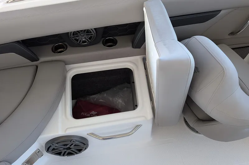 Slide: The Image of 2026 Four Winns HD5 OB boat interior with open storage compartment and speaker. - 9