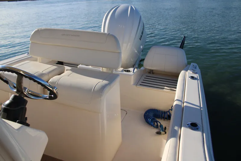 Slide: The Image of 2024 Grady-White Fisherman 216 boat interior with seating and steering wheel on water. - 13