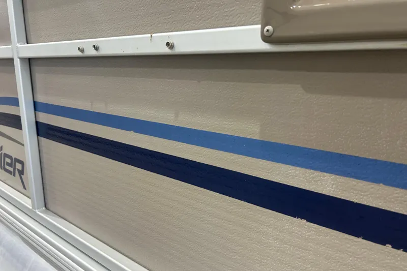 Slide: The Image of 2009 Premier 240 SunSpree boat side view with blue stripes and beige paneling. - 14