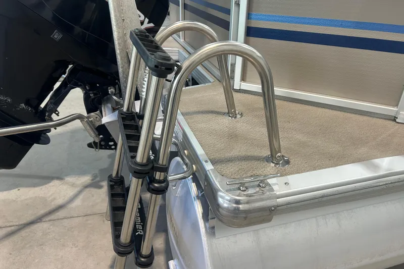 Slide: The Image of 2009 Premier 240 SunSpree boat ladder and motor detail, showcasing stainless steel and carpeted deck. - 16