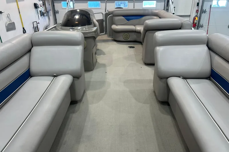 Slide: The Image of 2009 Premier 240 SunSpree pontoon boat interior with gray seating and blue accents. - 25