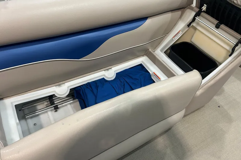 Slide: The Image of 2009 Premier 240 SunSpree boat interior storage compartments with blue fabric and beige seating. - 39