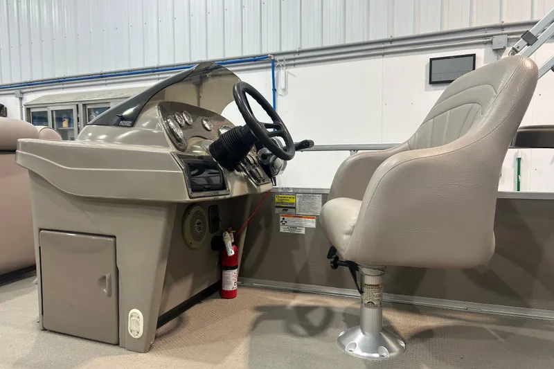 Slide: The Image of 2009 Premier 240 SunSpree boat helm with steering wheel and captain's chair in a showroom. - 41
