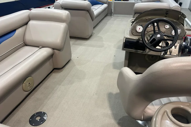 Slide: The Image of Interior of a 2009 Premier 240 SunSpree pontoon boat with beige seating and steering console. - 49