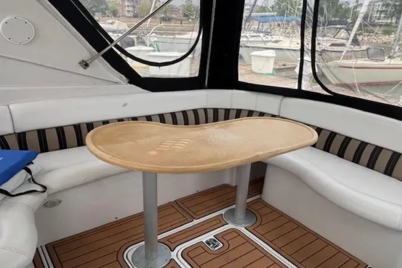 Slide: The Image of 2007 Four Winns 378 Vista boat interior with curved seating and wooden table. - 16