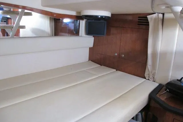 Slide: The Image of 2007 Sea Ray 340 Sundancer cabin interior with beige seating and wood paneling. - 11