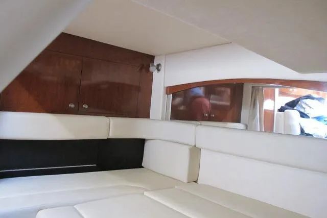 Slide: The Image of Interior cabin of 2007 Sea Ray 340 Sundancer with white seating and wooden cabinetry. - 12