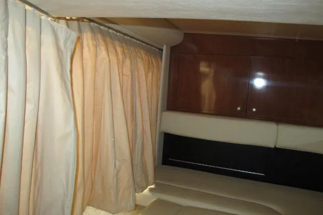 Slide: The Image of Interior cabin of 2007 Sea Ray 340 Sundancer with beige curtains and wooden cabinets. - 14