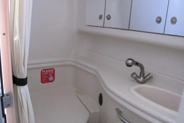 Slide: The Image of 2007 Sea Ray 340 Sundancer bathroom with sink, storage cabinets, and compact design. - 16