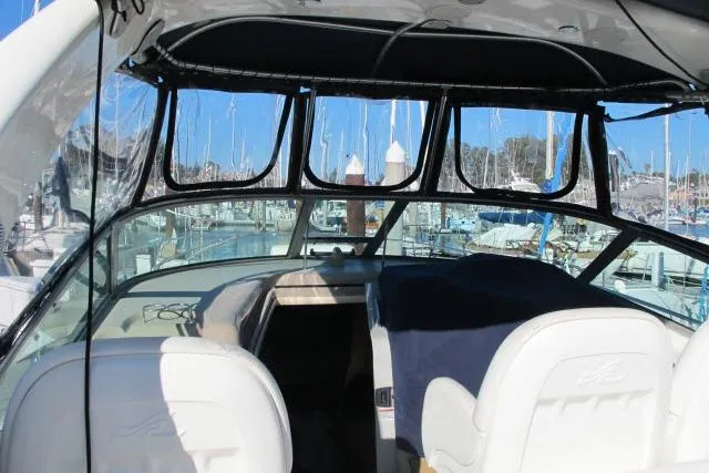 Slide: The Image of 2007 Sea Ray 340 Sundancer cockpit with marina view, featuring white seating and black canopy. - 25