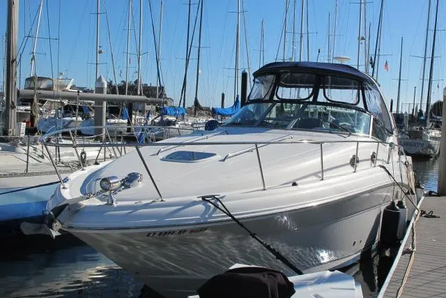Slide: The Image of 2007 Sea Ray 340 Sundancer docked at a marina with sailboats in the background. - 48