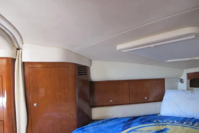 Slide: The Image of Interior cabin of 2007 Sea Ray 340 Sundancer with wooden cabinets and bedding. - 9
