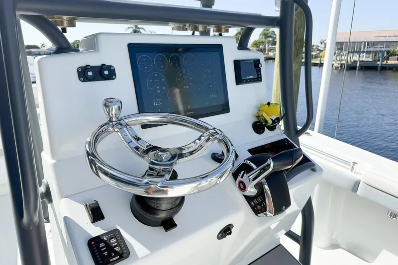The Image of Control panel of 2022 Yellowfin 26 Hybrid boat with steering wheel and digital display. - 0