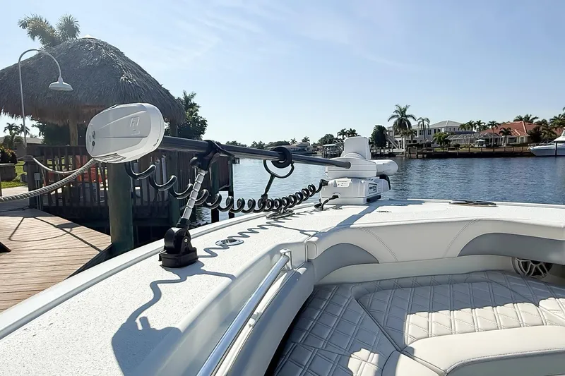 Slide: The Image of 2022 Yellowfin 26 Hybrid boat docked by a scenic waterfront with palm trees. - 6