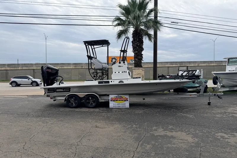 The Image of 2026 SCB R24 boat on trailer, parked outdoors near palm tree. - 0