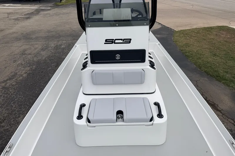 Slide: The Image of 2026 SCB R24 boat interior with seating and console, parked on pavement. - 22