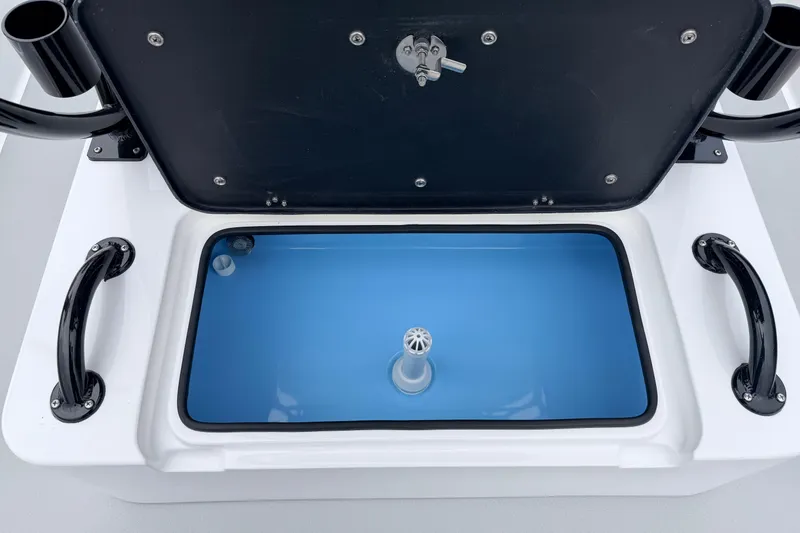Slide: The Image of Open livewell compartment in 2026 SCB R24 boat, featuring blue interior and black handles. - 26