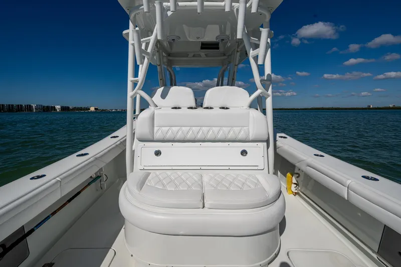 Slide: The Image of 2018 Yellowfin 36 Offshore boat interior with white seating, on calm water under blue sky. - 29