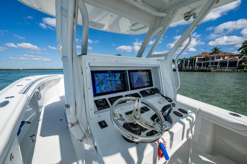 Slide: The Image of 2018 Yellowfin 36 Offshore boat dashboard with navigation screens on a sunny day. - 36