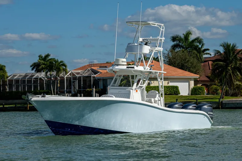 Slide: The Image of 2018 Yellowfin 36 Offshore boat cruising on a sunny day near waterfront homes. - 44