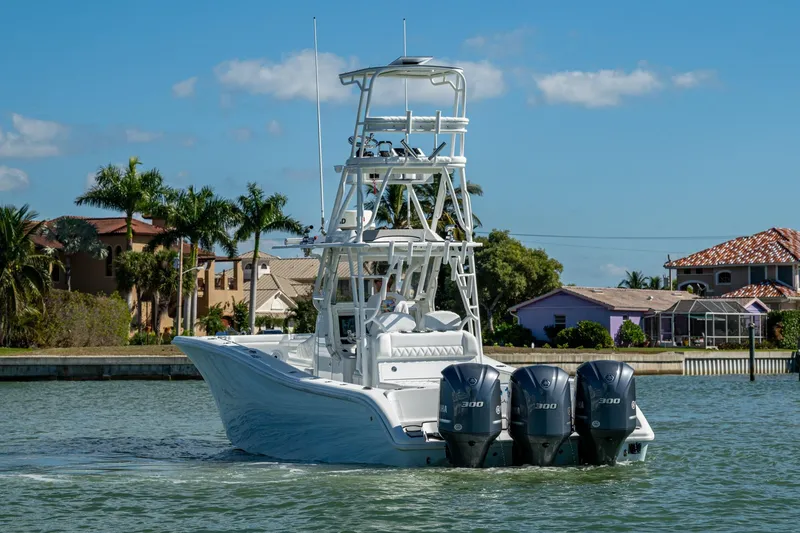 Slide: The Image of 2018 Yellowfin 36 Offshore boat with triple engines cruising near waterfront homes. - 57