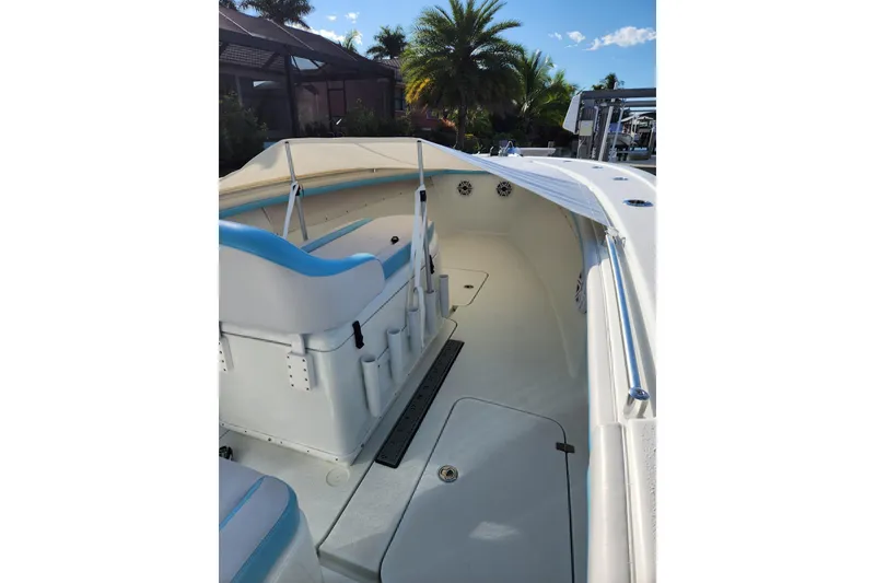 Slide: The Image of 2018 Yellowfin 36 Offshore boat interior with seating and canopy, surrounded by tropical scenery. - 66