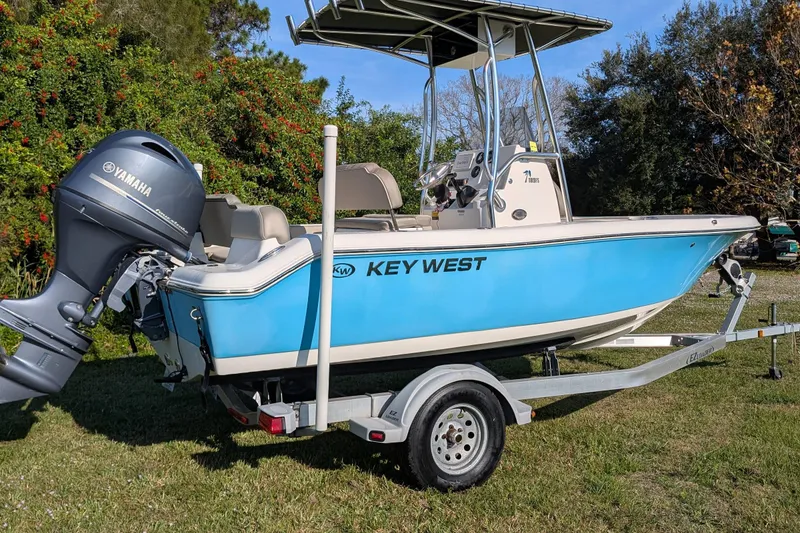 Slide: The Image of 2022 Key West 189 FS boat on trailer with Yamaha outboard motor, parked on grass. - 2