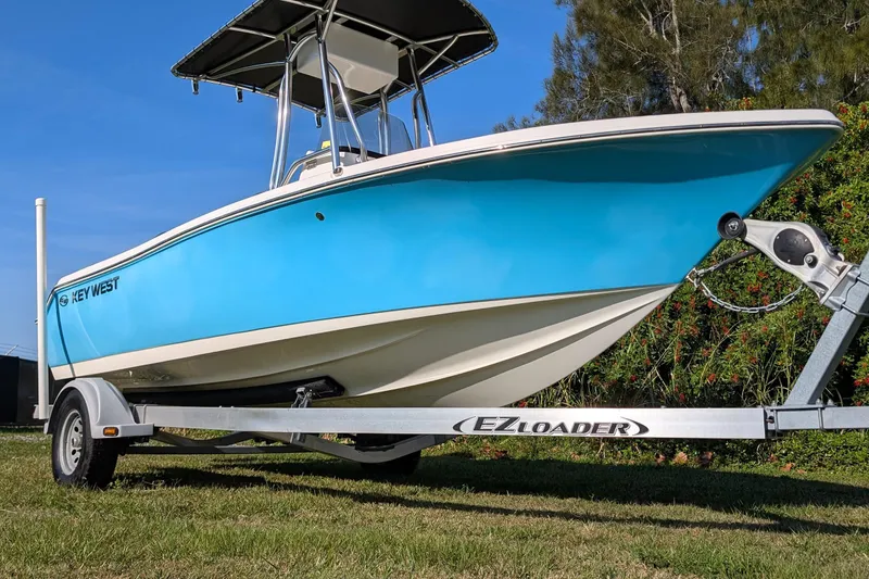 Slide: The Image of 2022 Key West 189 FS boat on EZ Loader trailer, vibrant blue hull, sunny day. - 4