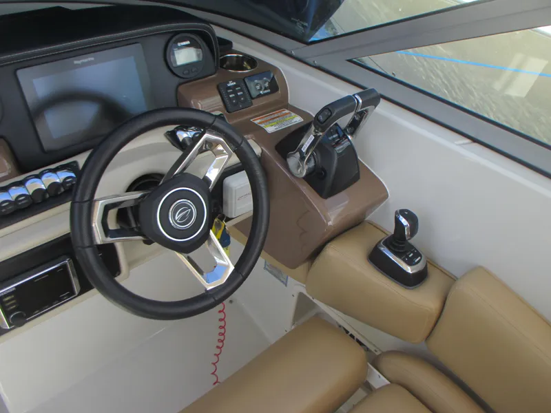 Slide: The Image of 2018 Crownline Eclipse E29 XS boat interior with beige seating and wood-style flooring. - 16