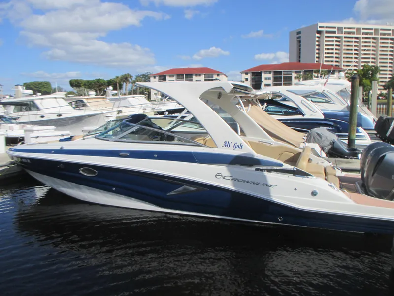 Slide: The Image of 2018 Crownline Eclipse E29 XS boat docked near waterfront home with palm trees. - 2