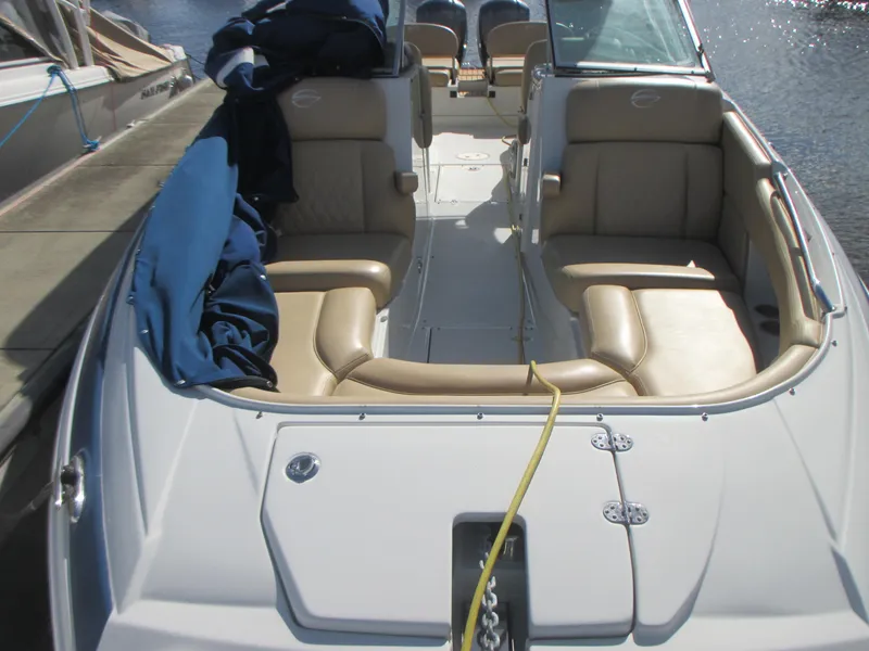 Slide: The Image of 2018 Crownline Eclipse E29 XS boat interior with tan seating and blue cover. - 29