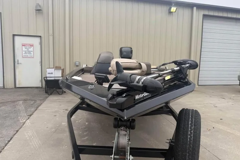 Slide: The Image of 2004 Express x17 boat with MotorGuide, parked outside a warehouse. - 2